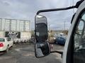 A 2008 International CityStar truck with side mirrors reflecting a construction site and parked vehicles