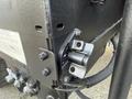 The image shows a close-up of a metallic component of a 2010 Autocar Xpeditor with bolts and a black finish visible