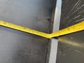 A measuring tape stretched across a metal surface showing measurements in inches