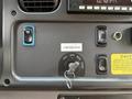 Dashboard of a 2022 Freightliner B2 showing ignition key slot buttons and warning labels