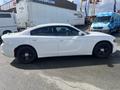 A white 2017 Dodge Charger with black wheels parked on the street