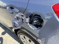 Close-up of the fuel door of a 2018 Kia Rio5 with the cap removed showing the fuel filler neck and warning labels inside