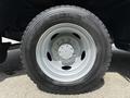 Close-up of a black tire mounted on a silver wheel designed for a 2008 Ford F-550 featuring deep treads and a bold brand name along the sidewall
