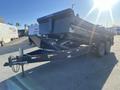 A 2024 Southland 18 foot dump trailer with a black metal body features a raised dumping mechanism and a hitch attached to a dual-axle frame