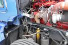 A blue 2015 Kenworth T660 truck with visible engine components including hoses and pipes, showcasing the intricate machinery and design of the vehicle