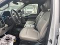 Interior view of a 2021 Ford F-550 showing front seats with light leather upholstery and a dashboard with controls and displays