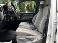 Interior view of a 2018 GMC Sierra 1500 showing the front driver's seat and center console with gray upholstery and seatbelts