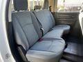 The interior back seat of a 2014 RAM 5500 featuring gray fabric upholstery and seat belts