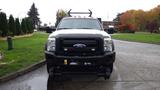 White 2011 Ford F-550 with a black front grill and snow plow attachment visible on the front