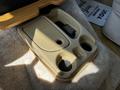 A beige console tray with two cup holders and a compartment for storage in a 2000 Ford Motorhome