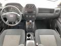 Interior view of a 2013 Jeep Liberty Sport featuring a dashboard with control knobs a gear shift and fabric seats in black and gray