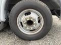 Close-up of a tire and wheel assembly from a 2017 Chevrolet Express featuring a silver wheel rim with visible lug nuts and a black tire tread