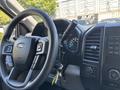 Interior view of a 2015 Ford F-150 showing the steering wheel dashboard and control panel with various buttons and gauges