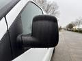 A close-up of the side mirror of a 2014 GMC Savana covered in raindrops