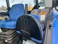 A blue and gray operator seat from a 2016 New Holland T475 tractor with a safety instruction label visible on the backrest