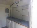 Interior of a 2004 Royal 18 foot office trailer featuring a long countertop a wall-mounted light fixture and a blank whiteboard