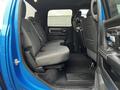 The interior of a blue 2021 RAM 1500 Classic showcasing the rear seating area with gray fabric seats and a clean floor mat