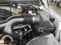 The image shows the engine compartment of a 2016 Ford F-150 focusing on the air intake system with a black air duct and engine components visible