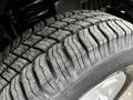 Close-up of a tire with a detailed tread pattern showcasing deep grooves and a textured surface on a 2011 Ford Econoline