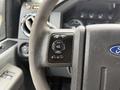 Close-up of the steering wheel and dashboard controls of a 2012 Ford F-550 showing buttons for setup info reset and set