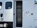A 2004 Freightliner M2 truck with an open side compartment revealing empty shelves inside
