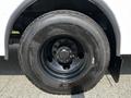 A close-up of the tire and wheel of a 2022 Blue Bird BB Conventional featuring a black rim and a treaded tire designed for durability and performance
