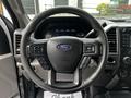 Steering wheel of a 2017 Ford F-250 featuring control buttons for audio and cruise settings with the Ford logo in the center
