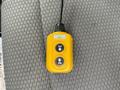 A yellow remote control with two buttons labeled UP and DN placed on a textured gray surface