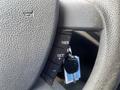 Close-up of the steering wheel controls and ignition key of a 2010 Ford Transit Connect showing buttons for resume and set