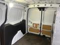 Interior view of a 2017 Ford Transit Connect showing the cargo area with two rear doors and bare walls ready for customization