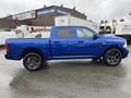 A blue 2019 RAM 1500 Classic truck is parked facing left with a crew cab design and black wheels