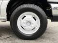 A close-up of a white wheel and tire from a 2019 Ford Econoline featuring a multi-spoke wheel design and rugged tread pattern