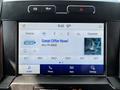 A touchscreen display showing radio sources and channels in a 2021 Ford F-550 vehicle