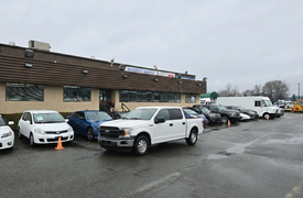 A white 2018 Ford F-150 parked in front of a building with various cars around it