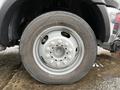 Close-up of a gray wheel from a 2012 Dodge Ram 5500 featuring a circular rim with multiple bolts and a treaded tire