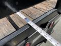 A metal tape measure extended across the wooden bed of a 2016 Ford F-550 truck