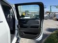 A 2016 GMC Sierra 1500 with the driver's side door wide open displaying the interior and door panel details