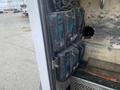 A 2015 Ford F-550 with a partially open door revealing two battery chargers mounted inside the vehicle