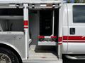 A 2009 Ford F-550 with an open service compartment revealing shelving and storage areas designed for equipment and tools
