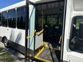 A 2017 Chevrolet Express bus with an open entrance featuring a ramp and yellow grab rails