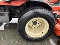A close-up of a rear tire from a 2012 Kubota F3680 featuring a thick tread pattern and a beige rim with five lug nut openings
