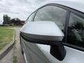 A silver 2025 Toyota Corolla with a focus on its side mirror showing its sleek design and modern features