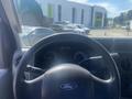 Steering wheel of a 2009 Ford Econoline with Ford logo and dashboard gauges visible in the background