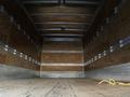 An empty interior of a 2014 International TerraStar truck with wooden walls and a flat wooden floor