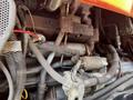 Close-up view of the engine components of a 2011 Kubota M8540D including wiring hoses and metal parts