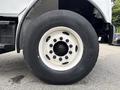 Close-up of a white wheel and tire on a 1998 Freightliner FL80 showing the hub and lug nuts