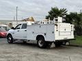 A 2013 RAM 3500 service truck with a white exterior featuring a utility bed and tool compartments on the sides