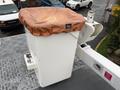 A white utility bucket on a truck with a brown protective cover on top
