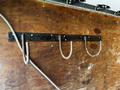 A metal rack with three hooks mounted to a wooden surface