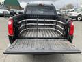 A black 2004 Ford Explorer Sport Trac with an open truck bed featuring metal fencing and a lined floor